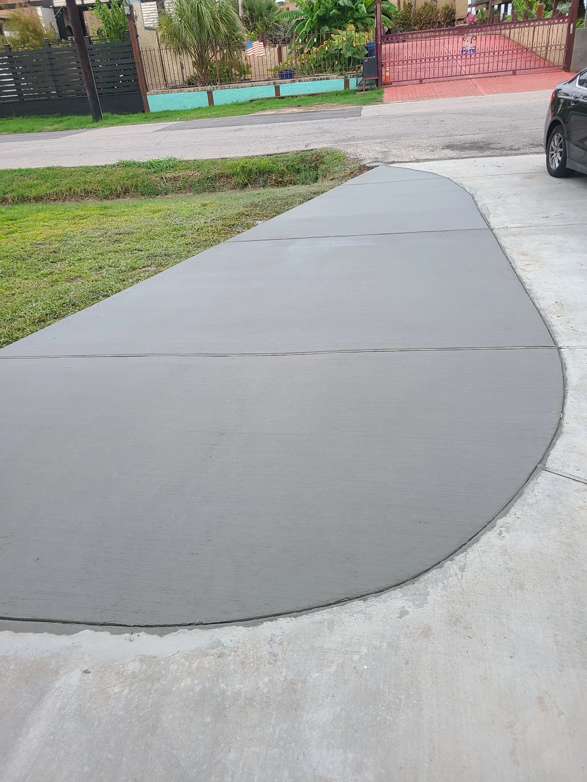 Rounded concrete apron connecting to existing concrete