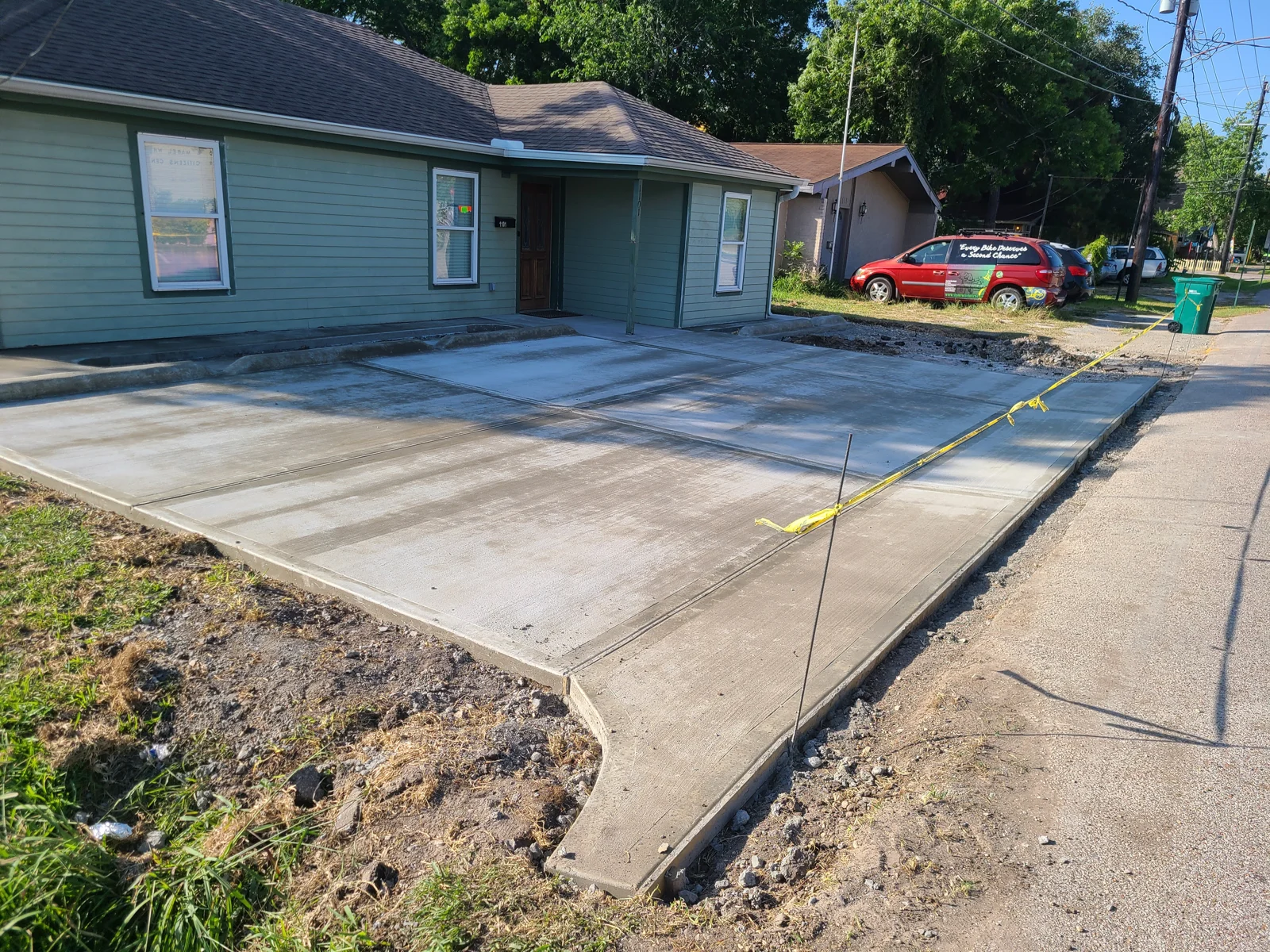 Concrete driveway and raised edge along a home