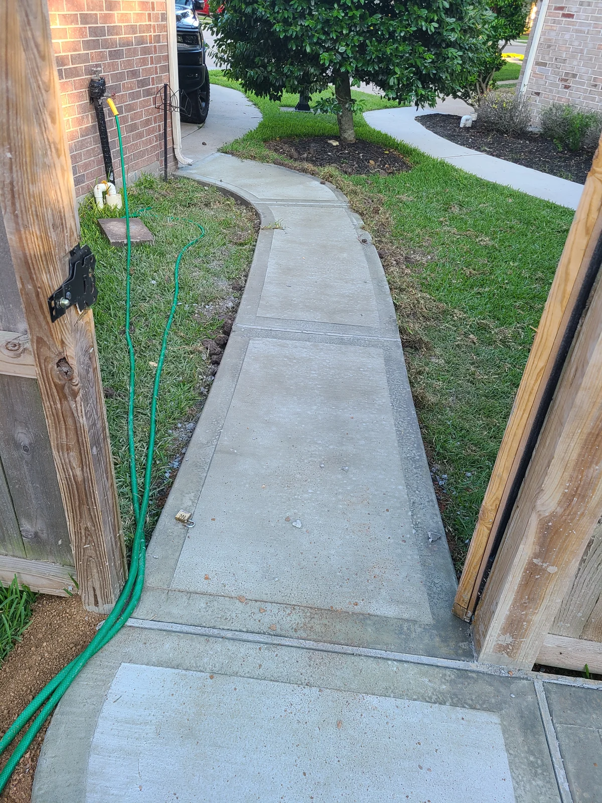 Concrete walkway running alongside a brick home