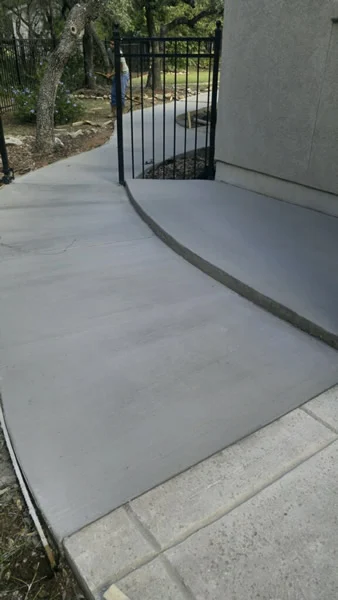 Curved concrete walkway beside a house