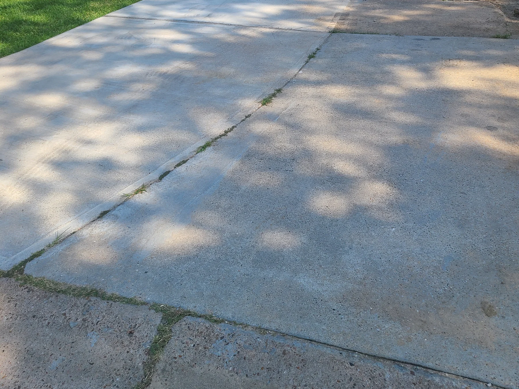 Residential driveway extension beside existing concrete, photographed June 2023
