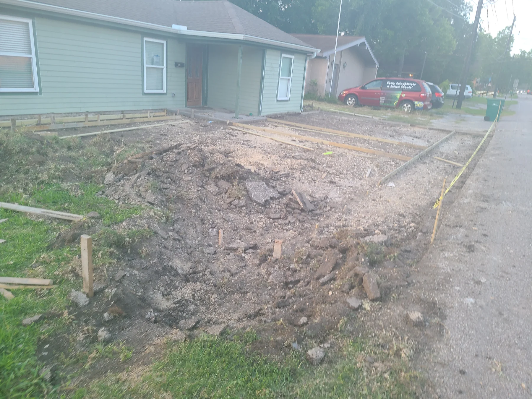 Site preparation and concrete forms in front of a green-sided home before the pour, photographed May 2022