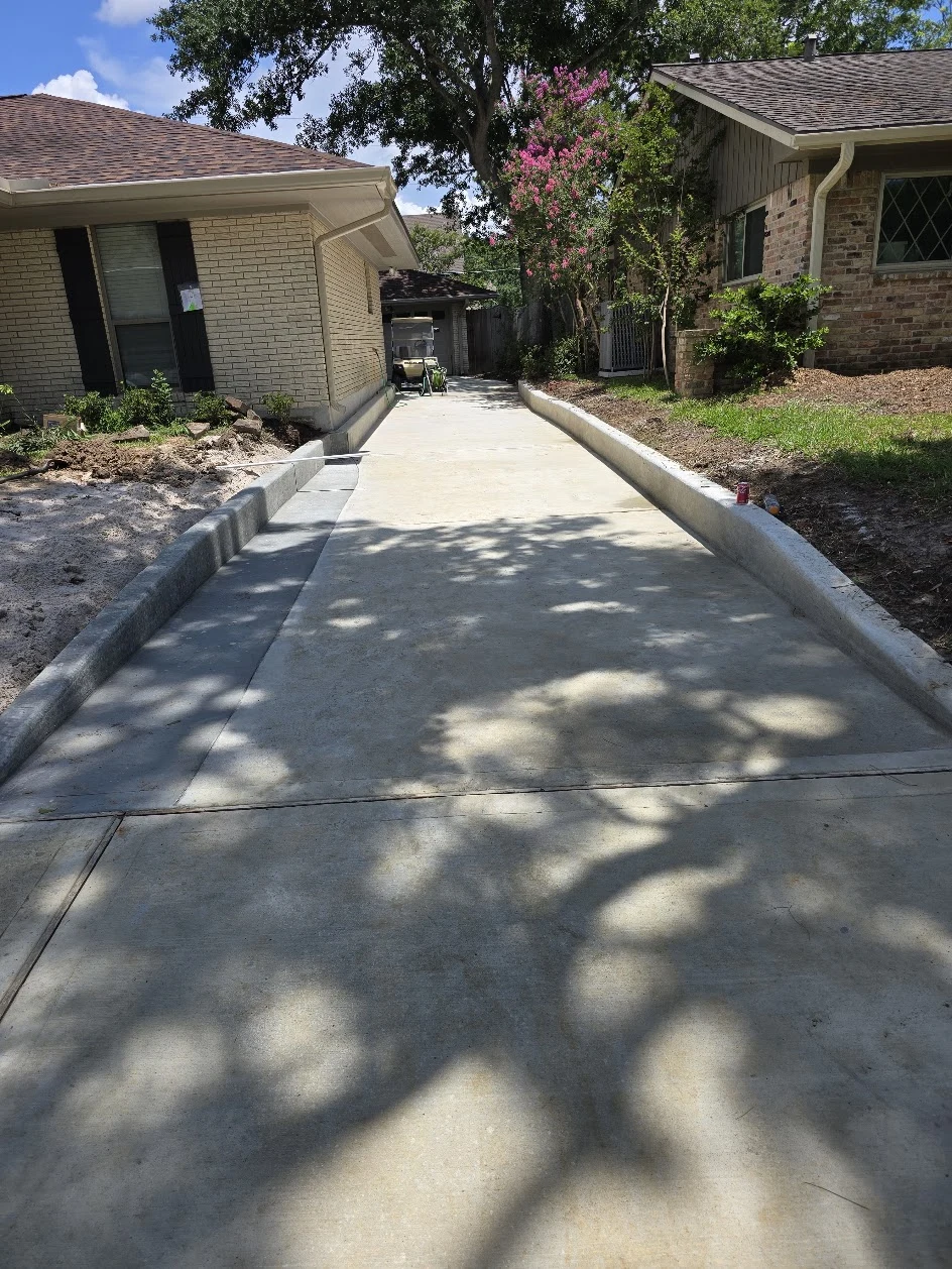 Concrete driveway with raised edge details, photographed June 2025